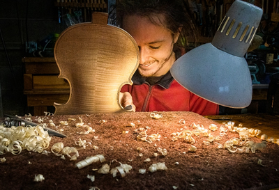 Photo of Alex Buktenica, luthier, working on a violin